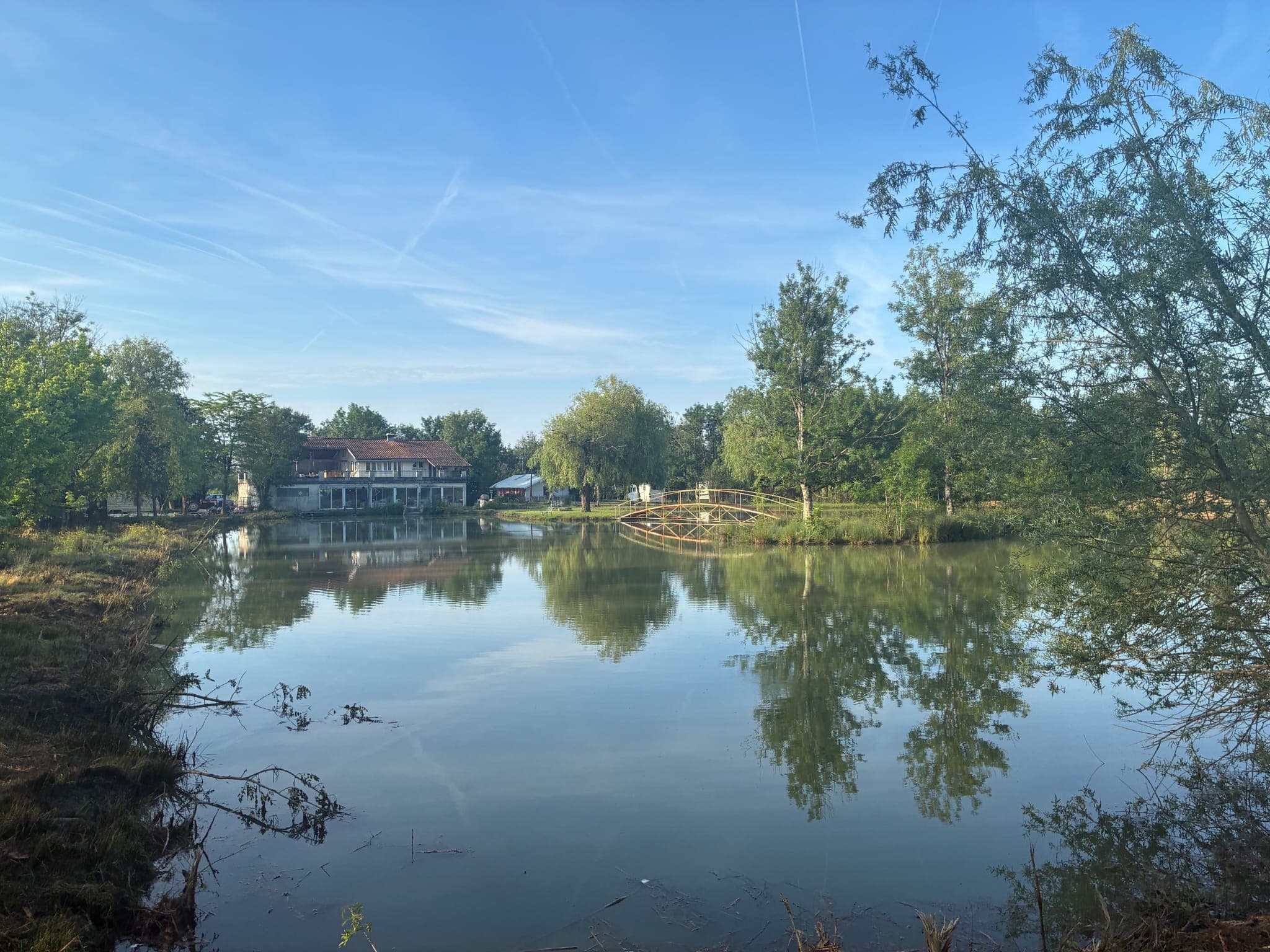 Lac avec la guinguette et le pont en bois au fond, matin calme